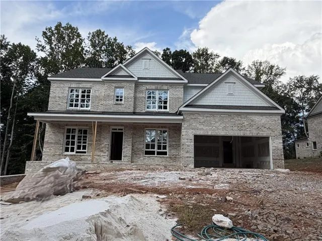Two-story brick exterior with gabled roof lines, multiple pane windows, and an integrated two-car garage