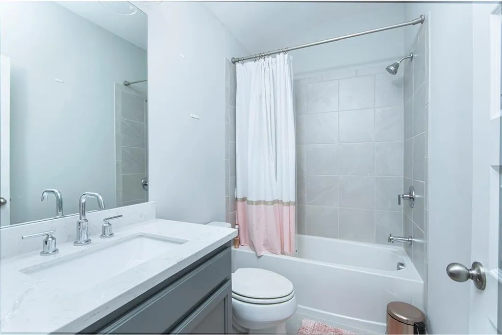 Bathroom with vanity and shower / tub combo with curtain