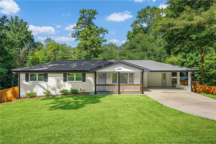 Charming single-story residence featuring a fresh stucco exterior with board-and-batten accents, complemented by a covered front porch with wooden railings