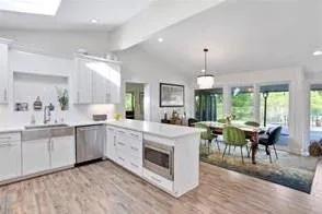 Kitchen featuring white cabinetry, appliances with stainless steel finishes, light porcelain  flooring