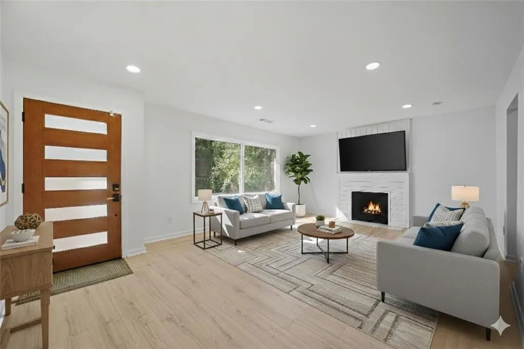 Living area featuring a fireplace, light wood-style floors, and recessed lighting. Virtual staging