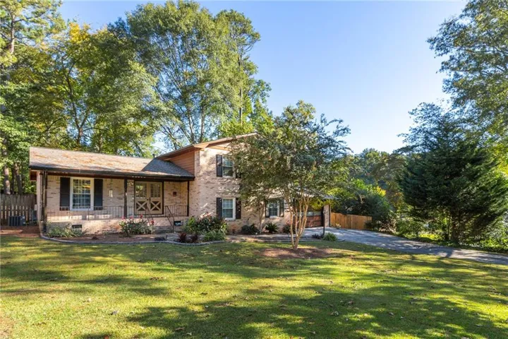 Split-level brick exterior with a covered front porch and contrasting dark shutters