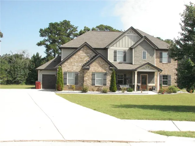 Brick and siding exterior with a covered entry, attached two-car garage, and concrete driveway