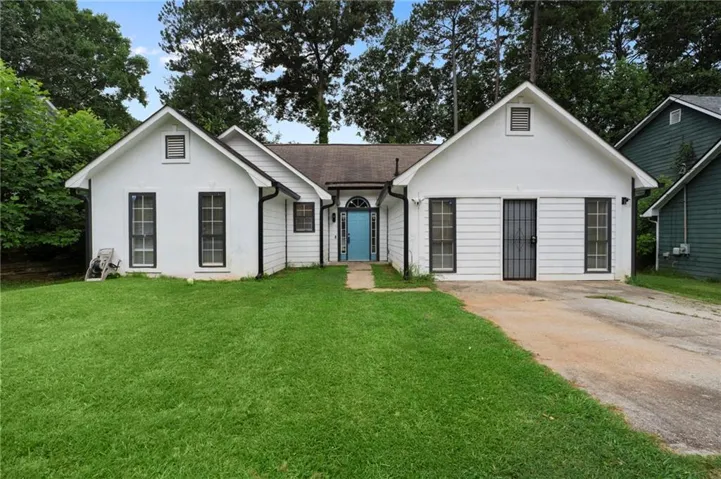 White exterior with contrasting black trim windows and a prominent blue front door.