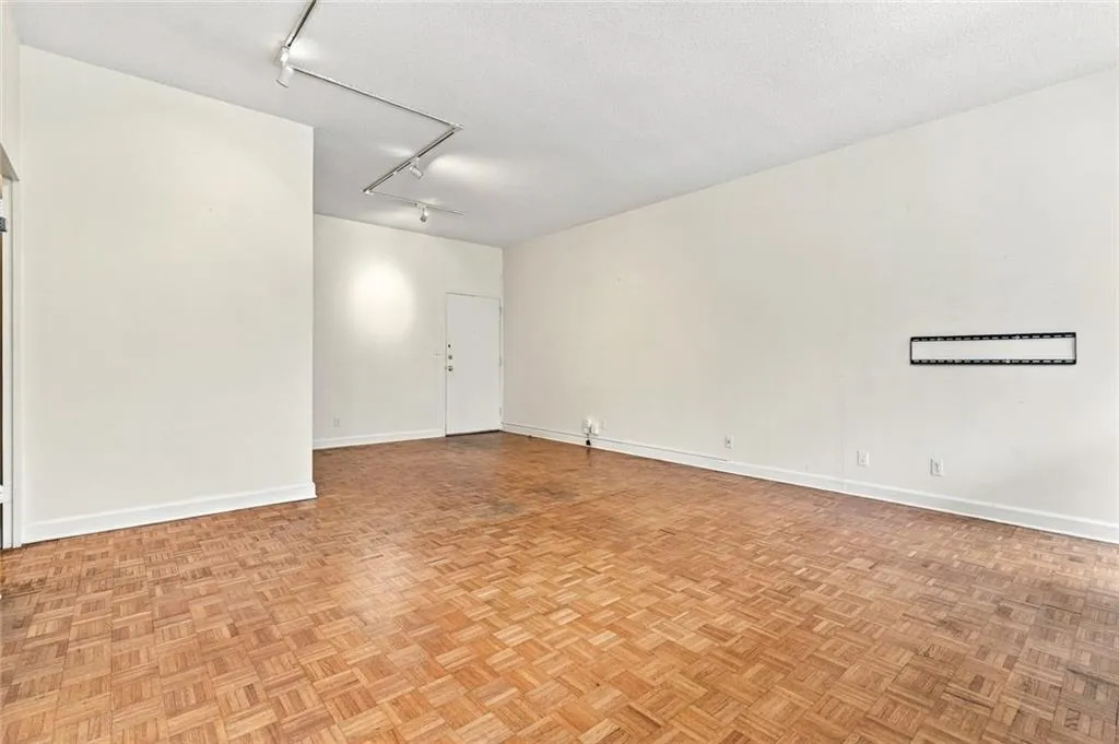 Parquet wood-finish flooring, track lighting, and a wall-mounted bracket