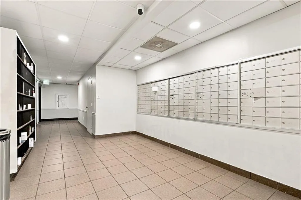 Hallway featuring tiled flooring, recessed lighting, and a wall of individual mailboxes