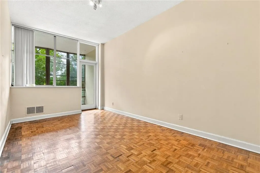 Parquet wood-finish flooring, full-height windows, and a glass-paneled door