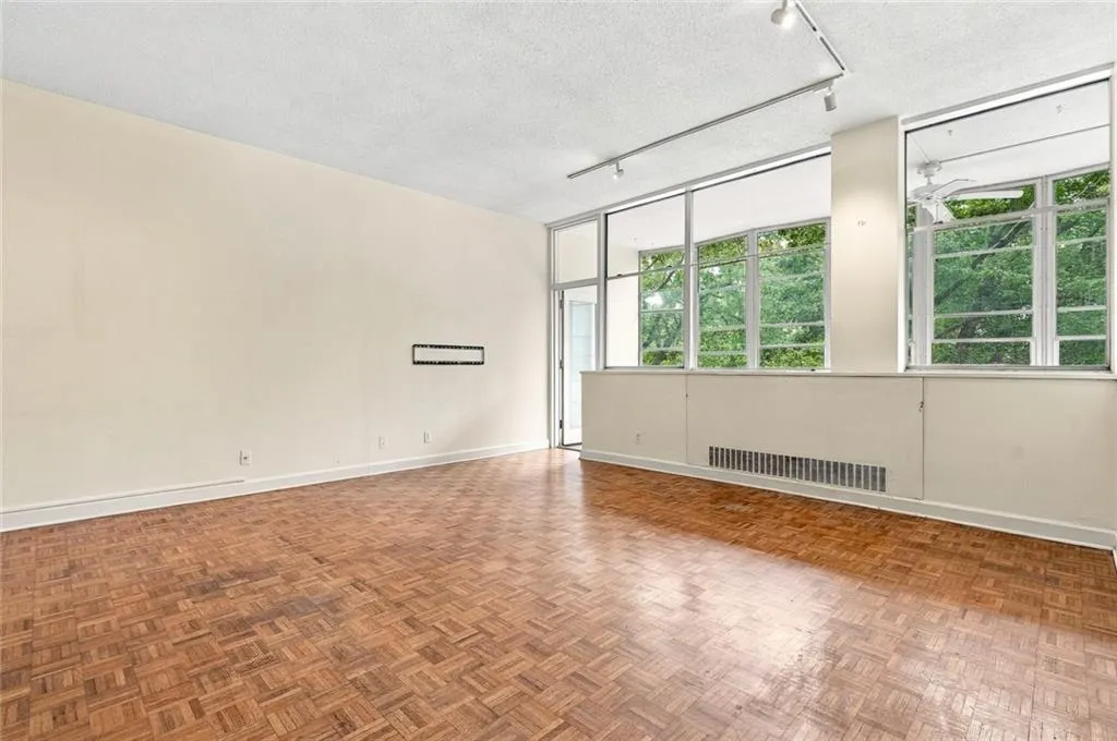 Parquet flooring, expansive wall-to-wall windows, track lighting, and a ceiling fan