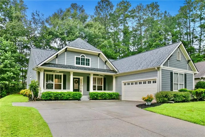 Siding exterior with a covered porch, attached garage, and a concrete driveway