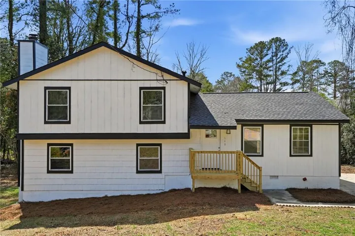 Split level home with crawl space, a shingled roof, and a front yard