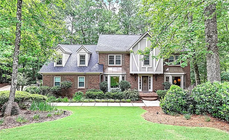 Brick and siding exterior featuring a prominent front entrance with a large bay window