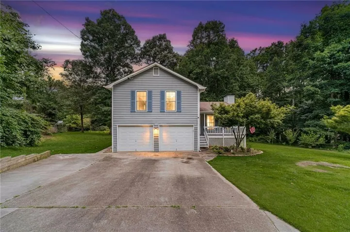 Gray siding exterior with blue window shutters, featuring a two-car garage with individual doors
