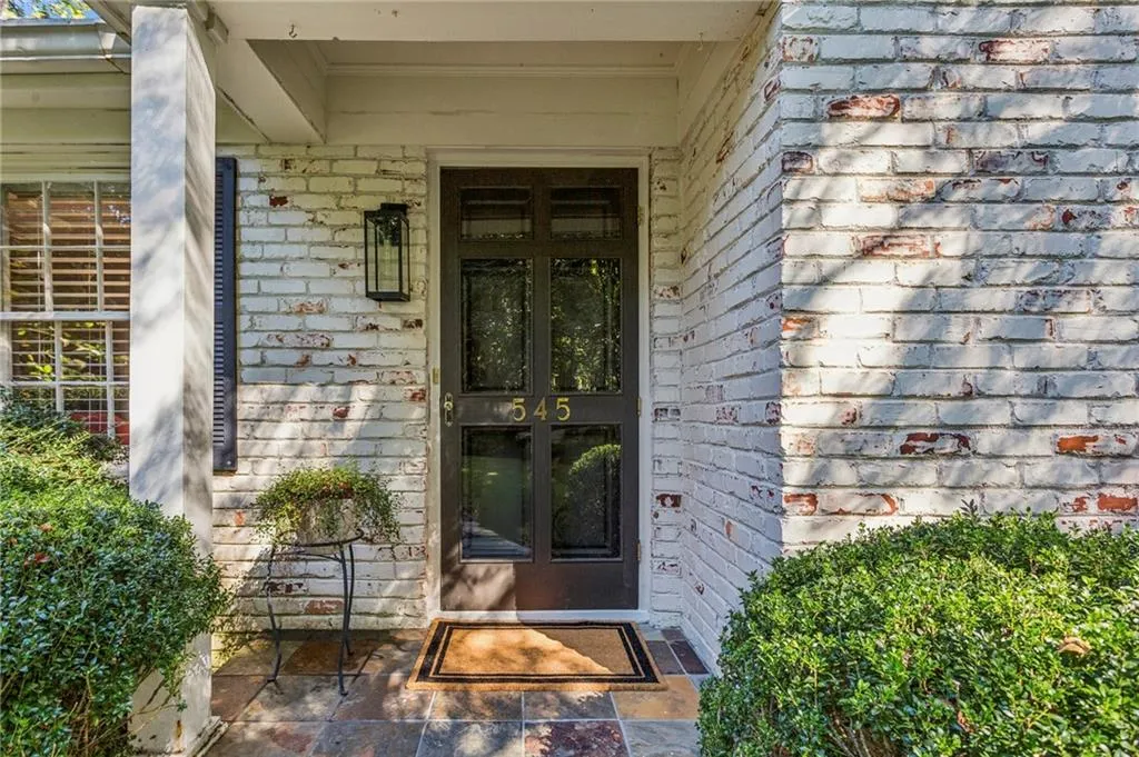 Property entrance with brick siding and covered porch