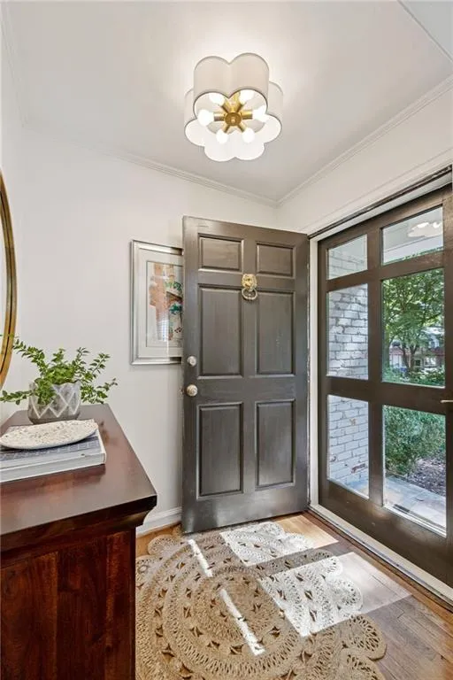 Entryway featuring crown molding and wood finished floors