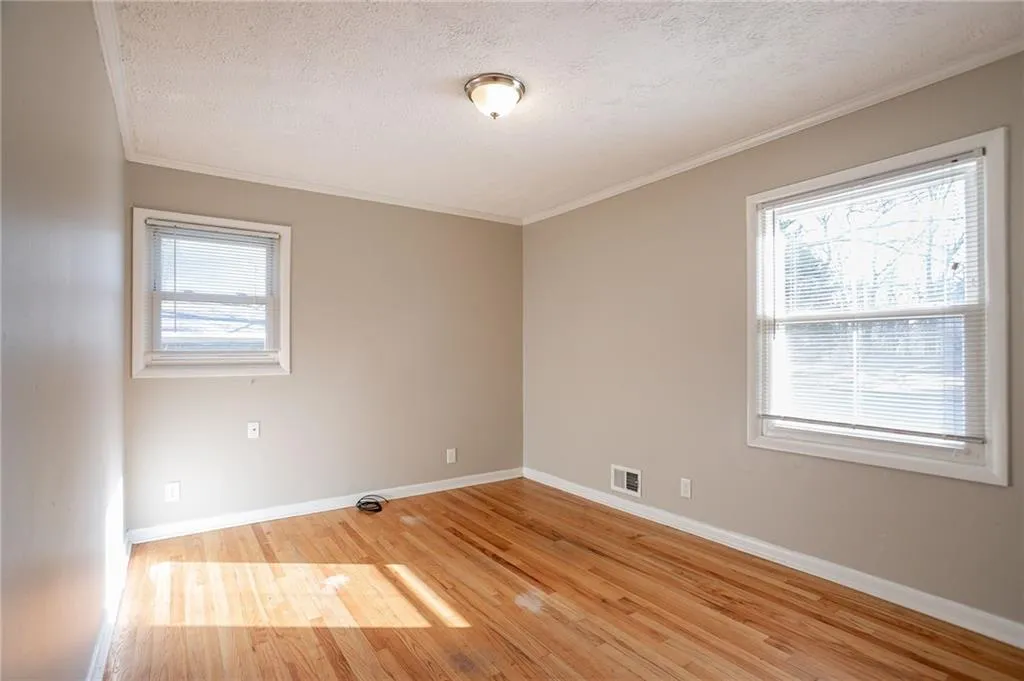 Unfurnished room featuring visible vents, a textured ceiling, and a healthy amount of sunlight