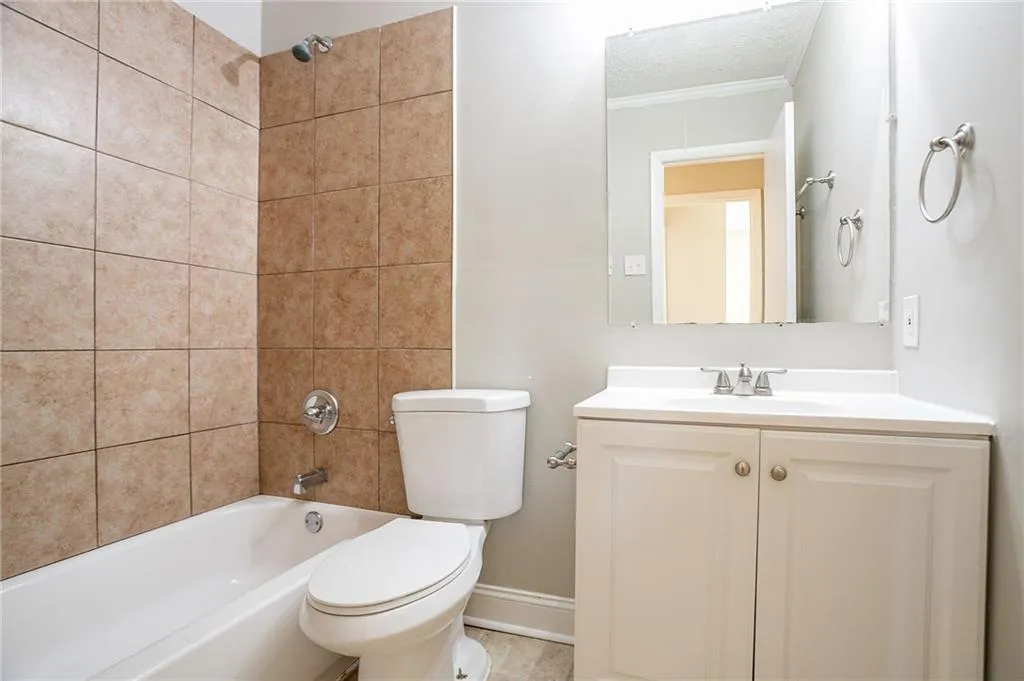 Full bathroom with vanity, baseboards, tub / shower combination, a textured ceiling, and toilet