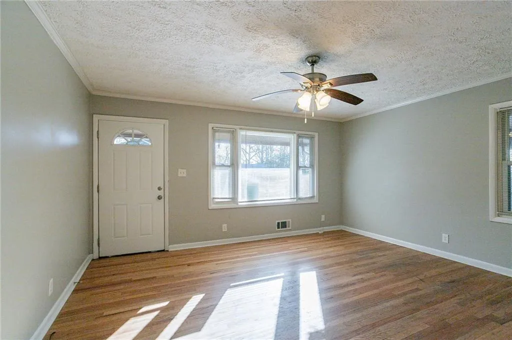 Entrance foyer featuring visible vents, a textured ceiling, crown molding, and baseboards