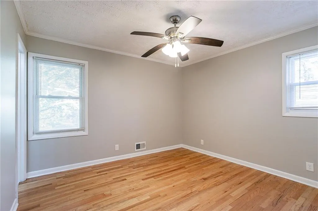 Spare room with crown molding, visible vents, and a textured ceiling