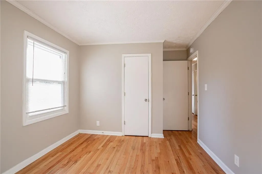 Unfurnished bedroom with crown molding, baseboards, and a textured ceiling