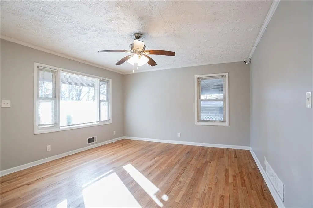 Spare room featuring crown molding, baseboards, and visible vents