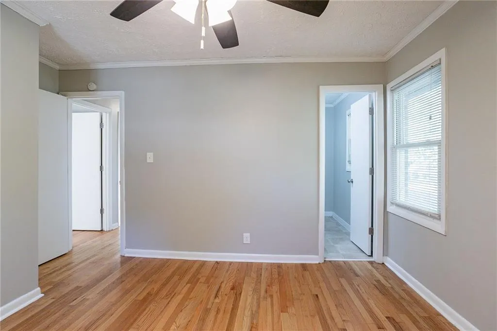 Empty room with a textured ceiling, and ornamental molding