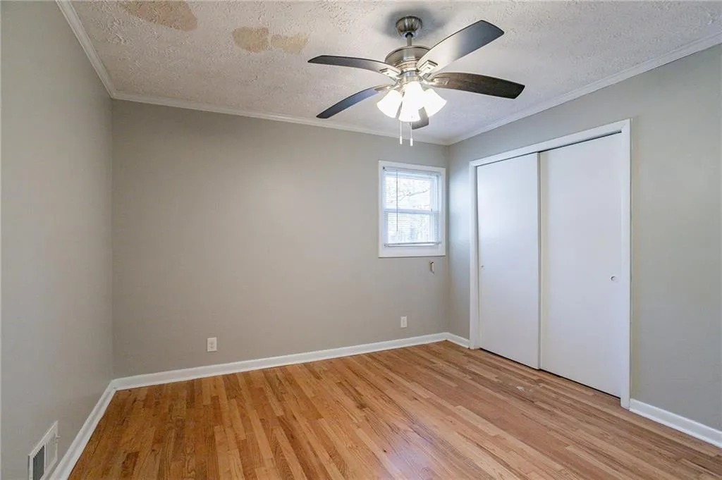 Unfurnished bedroom featuring visible vents, and ornamental molding