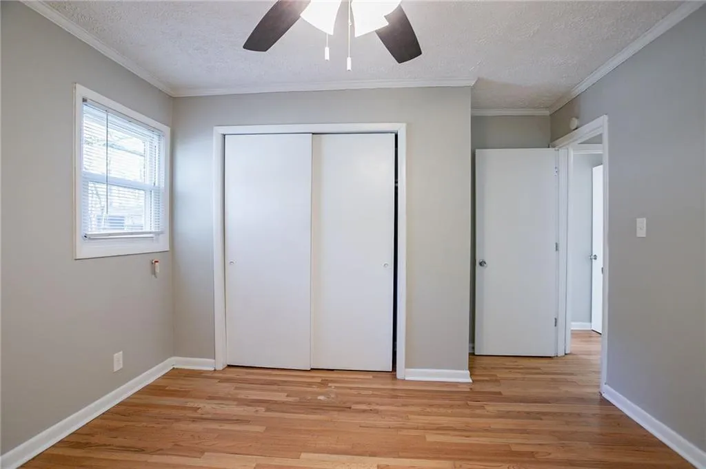 Unfurnished bedroom featurin, a textured ceiling, a closet, and ornamental molding