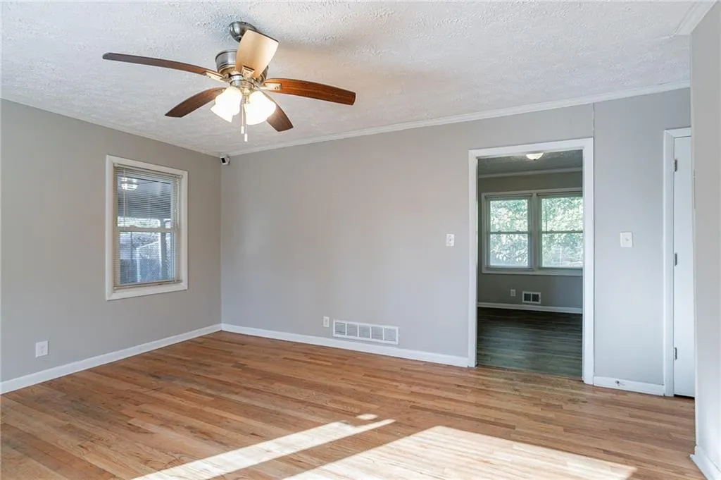 room featuring crown molding, visible vents, and a textured ceiling