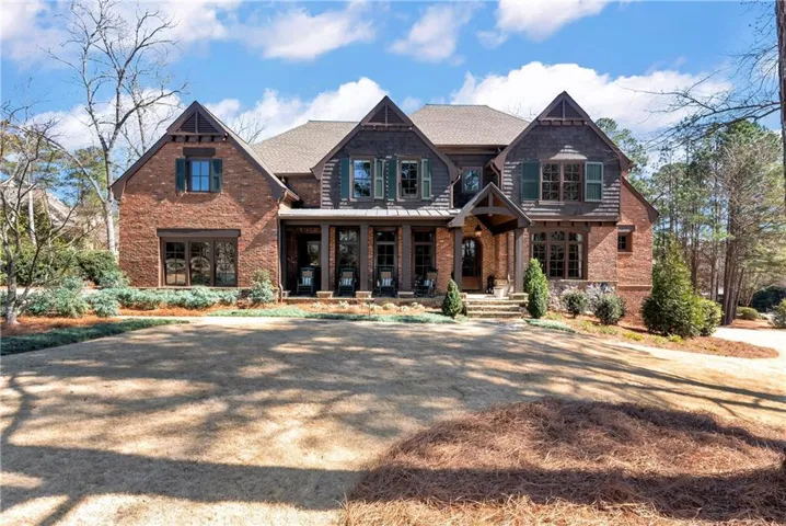 Brick and wood shake exterior featuring multiple gables, covered entry porch, and stone accents