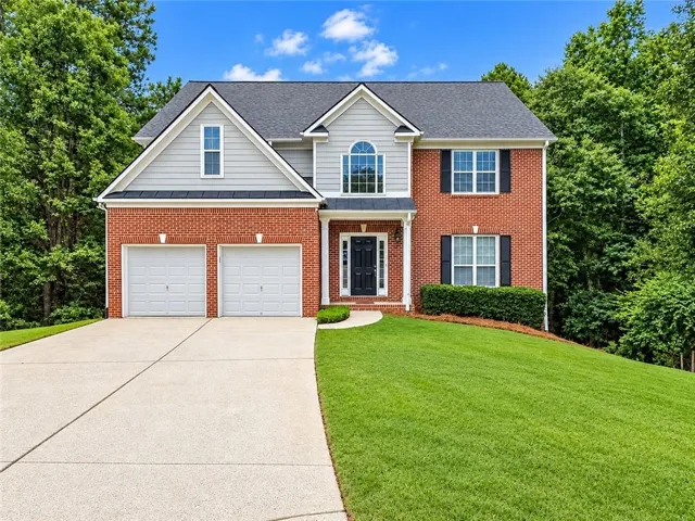 Red brick and siding exterior with a two-car garage