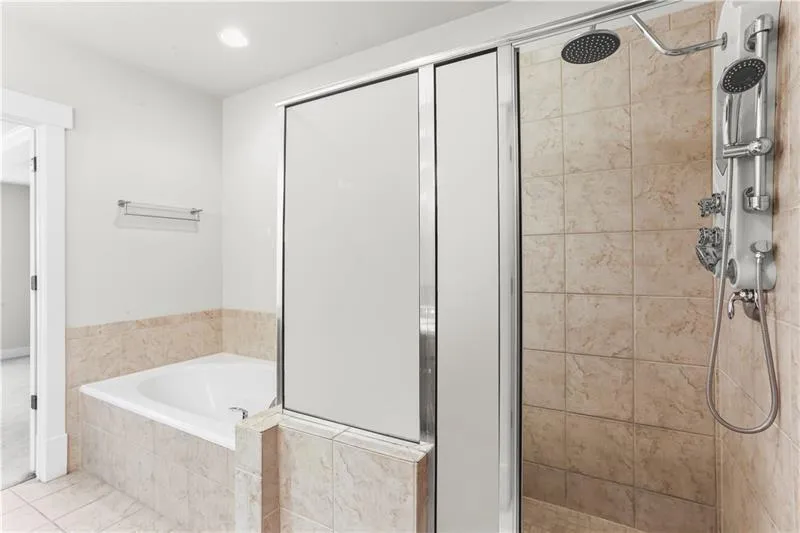 Bathroom with a stall shower, a garden tub, tile patterned flooring, and recessed lighting