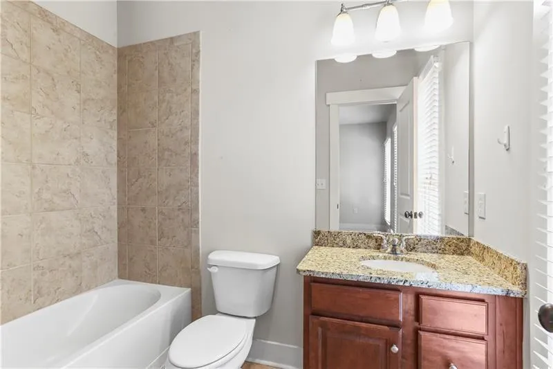Full bathroom with toilet, vanity, baseboards, and bathing tub / shower combination