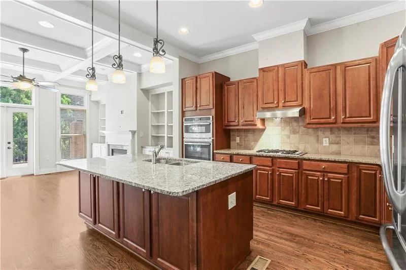 Kitchen with appliances with stainless steel finishes, ceiling fan, dark wood-style flooring, under cabinet range hood, and recessed lighting