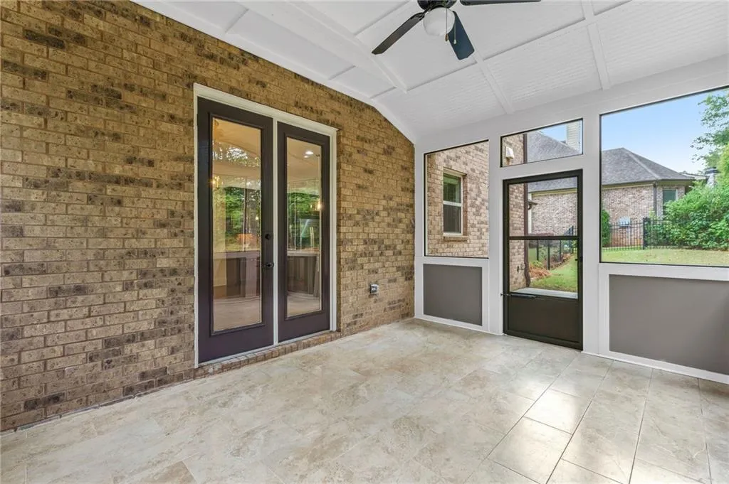 Sunroom featuring ceiling fan, vaulted ceiling with beams, and french doors