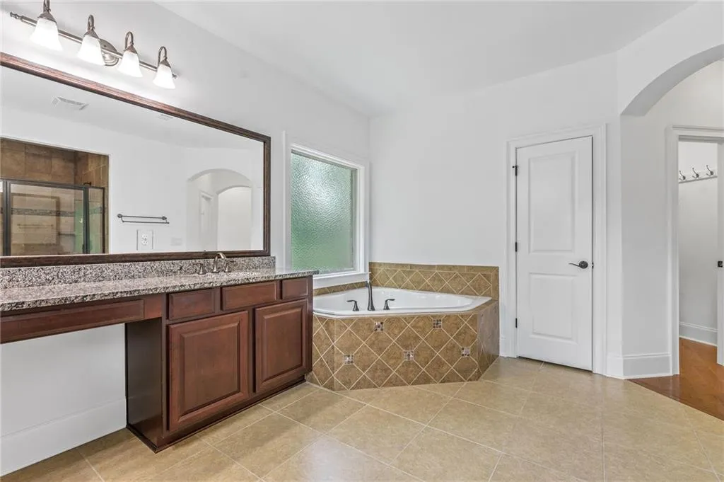 Primary Bathroom with independent shower and bath, tile patterned flooring, and vanity