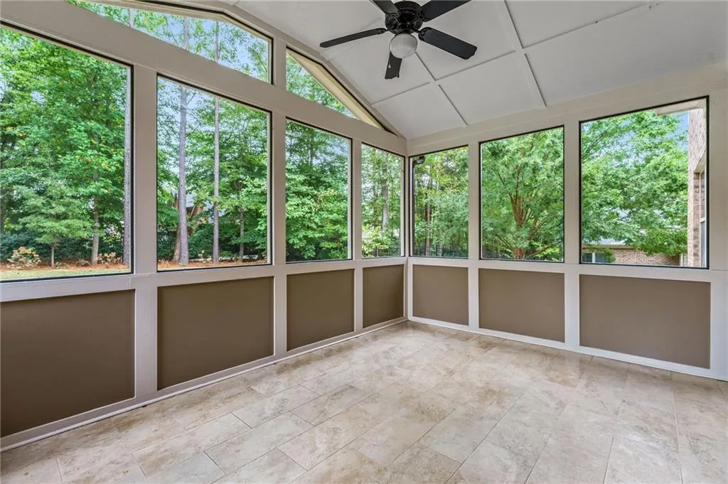 Sunroom featuring a healthy amount of sunlight, vaulted ceiling, and ceiling fan