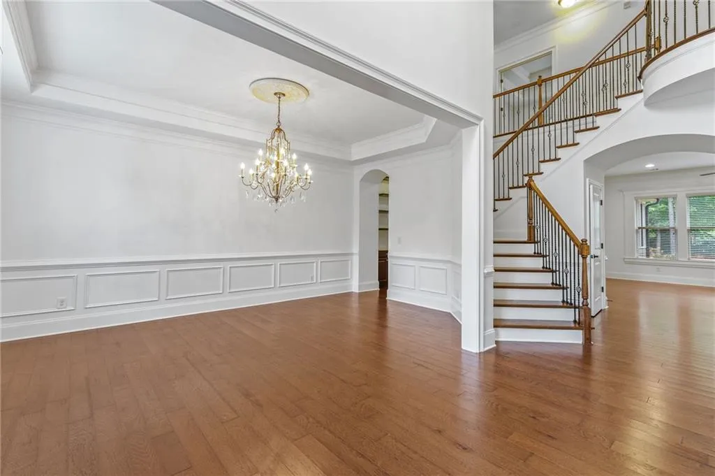 Dining room /foyer wood-style flooring, a tray ceiling, and ornamental molding