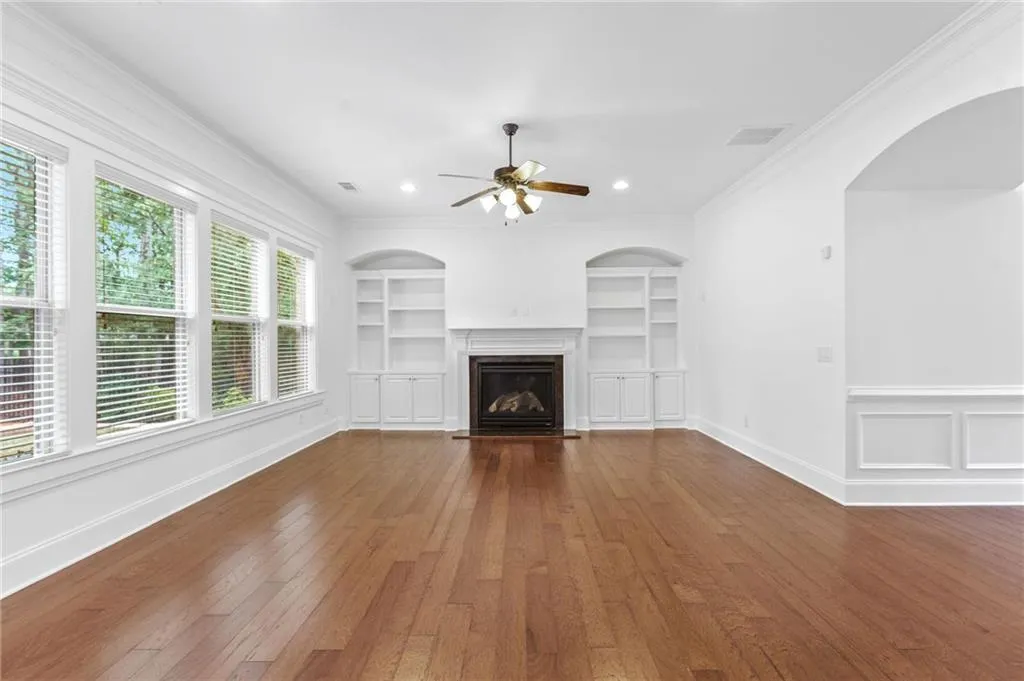 Living room with a healthy amount of sunlight, ornamental molding, and dark hardwood / wood-style floors