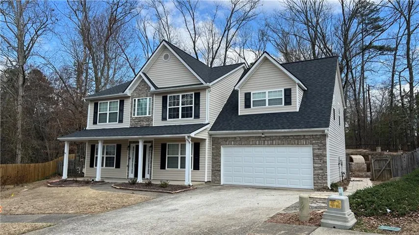 Charming two-story colonial with crisp white siding and dark architectural shingles