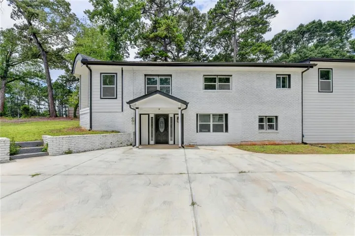 Contemporary two-story exterior featuring white painted brick and white siding
