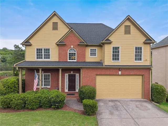 Two-story residence featuring a brick and siding facade with a covered front porch