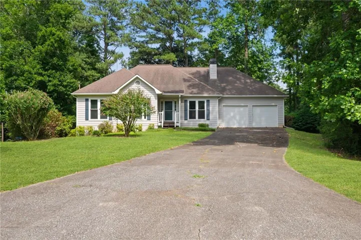 Ranch-style exterior featuring light-colored siding, a two-car garage, and a central entryway