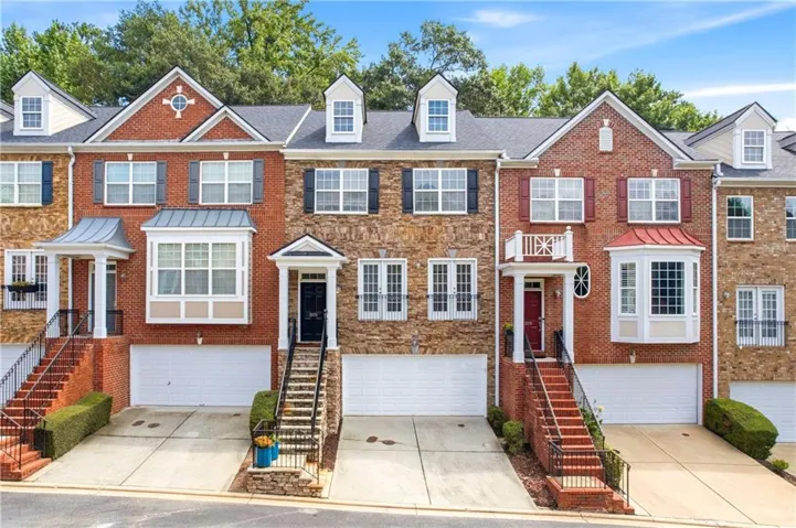 Brick and stone exterior with architectural dormers, an integrated garage, and a covered entry