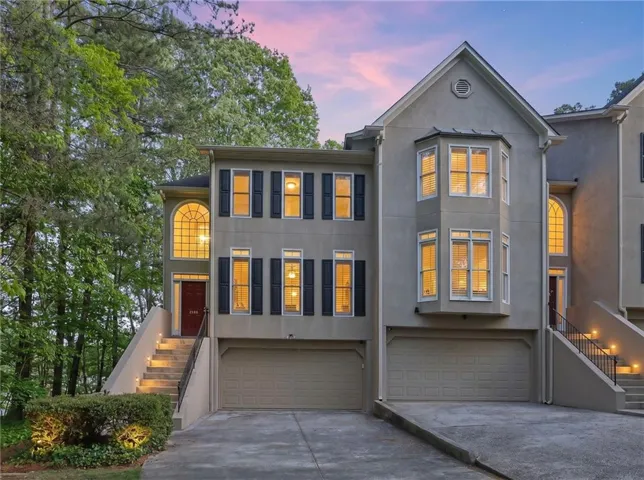 Stucco exterior with multiple bay windows and arched window features