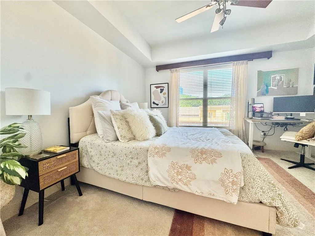 Carpeted bedroom featuring a desk and a ceiling fan