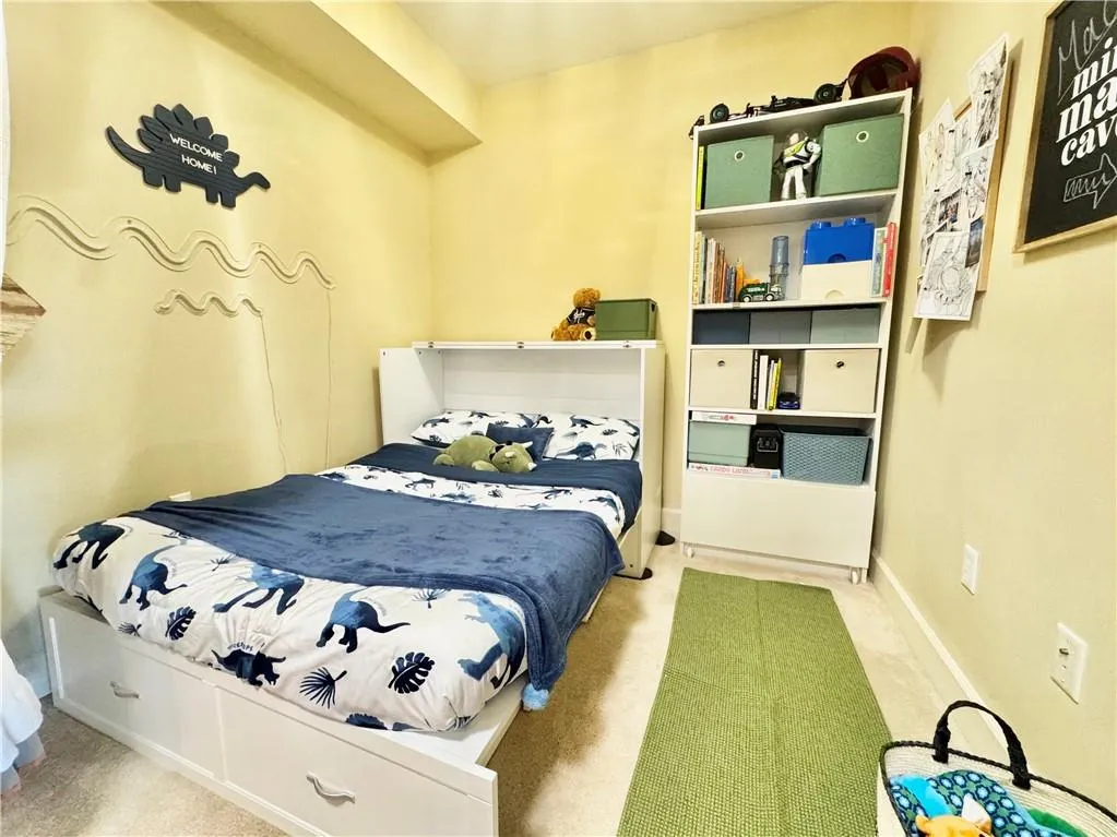Bedroom featuring light carpet and baseboards