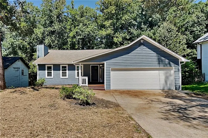 Siding exterior, attached garage, concrete driveway, front porch, and detached storage shed