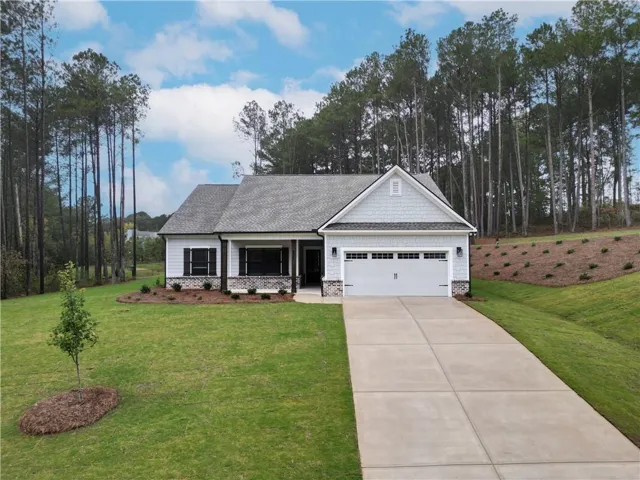 Modern ranch-style residence featuring a prominent two-car garage, gray shingle siding, and a stone facade
