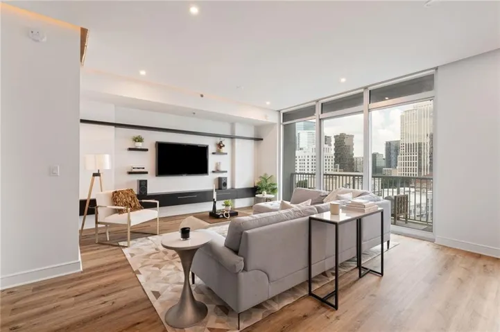 Spacious living area featuring wood-finish flooring, recessed lighting, and a built-in media console