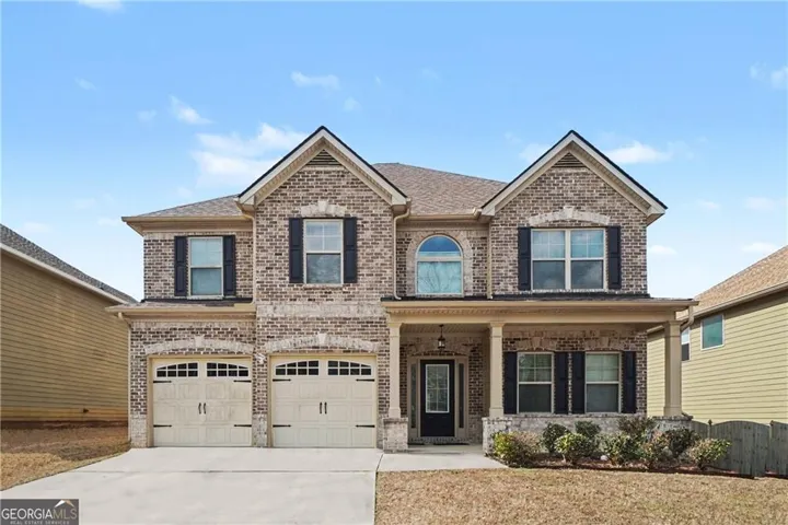 Brick veneer exterior with a two-car garage, covered porch, and arched upper window